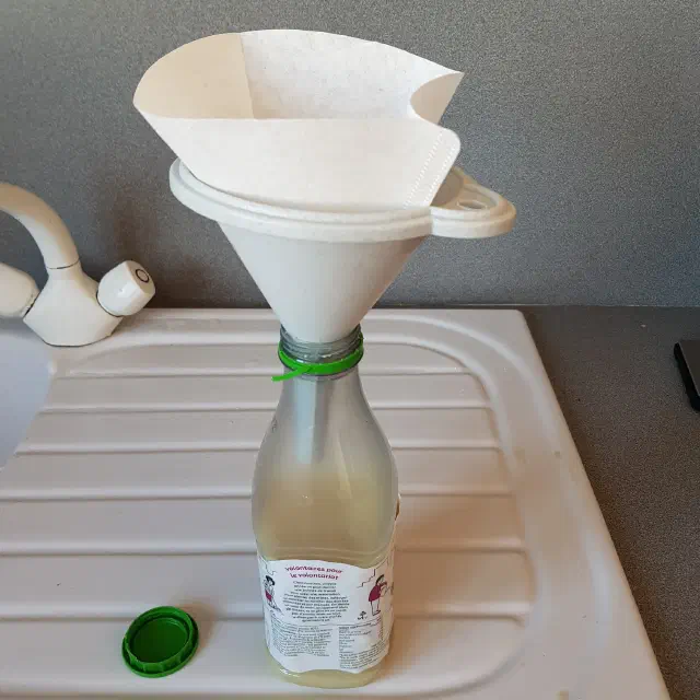 Bouteille surmontée d'un entonnoir.