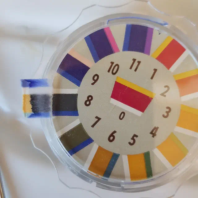 Papier pH et teintes de référence indiquant un pH de 8.