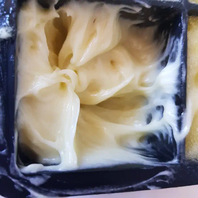 Moule à glaçon carré rempli d'une pâte jaune.